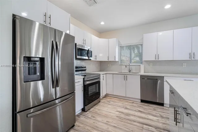 a kitchen with stainless steel appliances cabinets a refrigerator and a sink