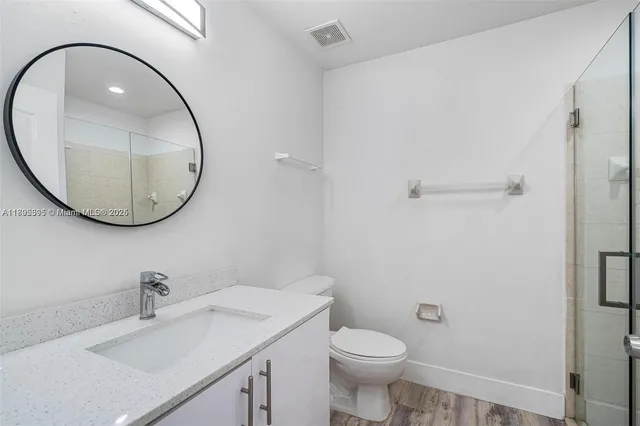 a bathroom with a sink a mirror a toilet and a mirror