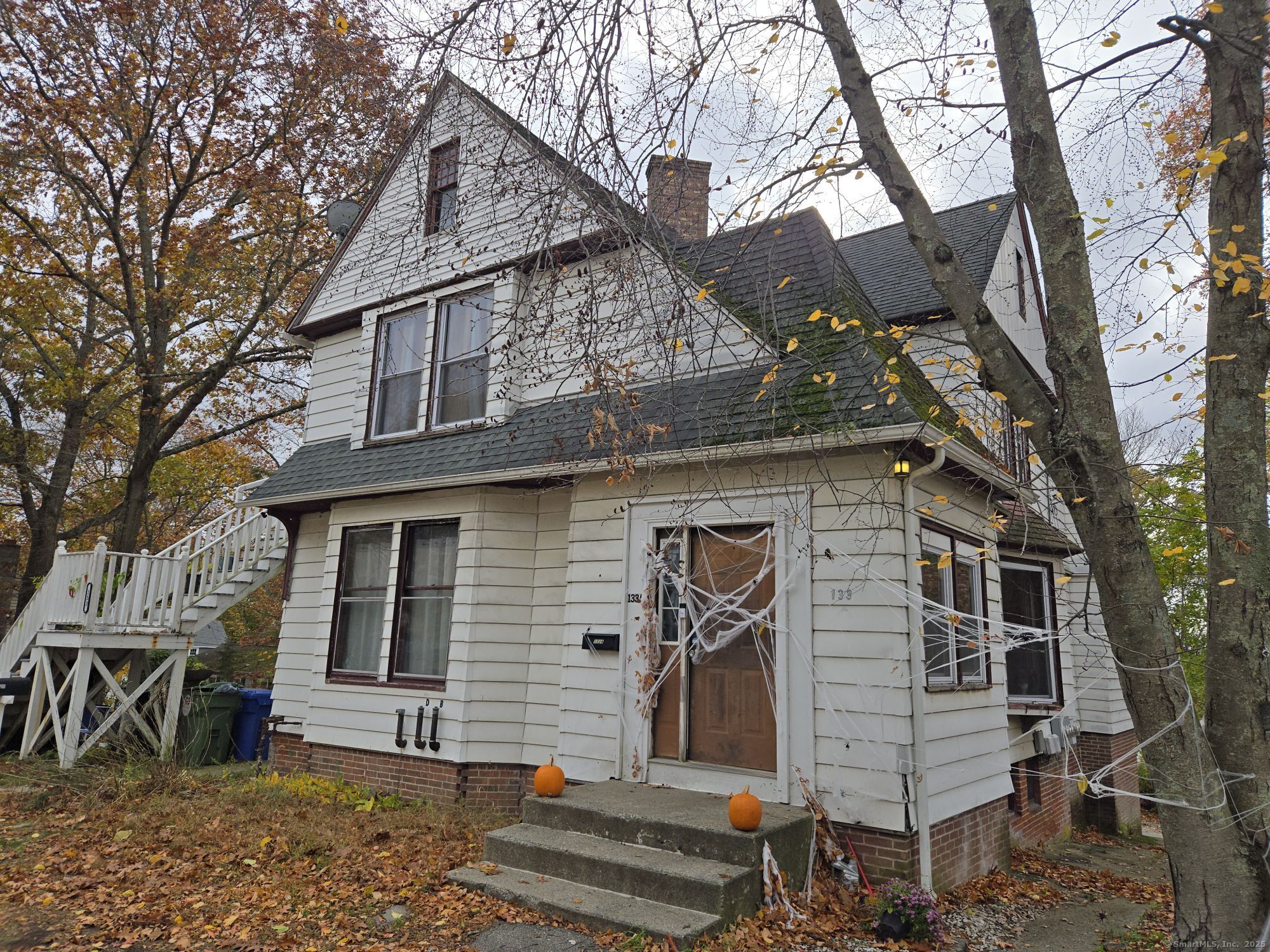 a front view of a house with a tree