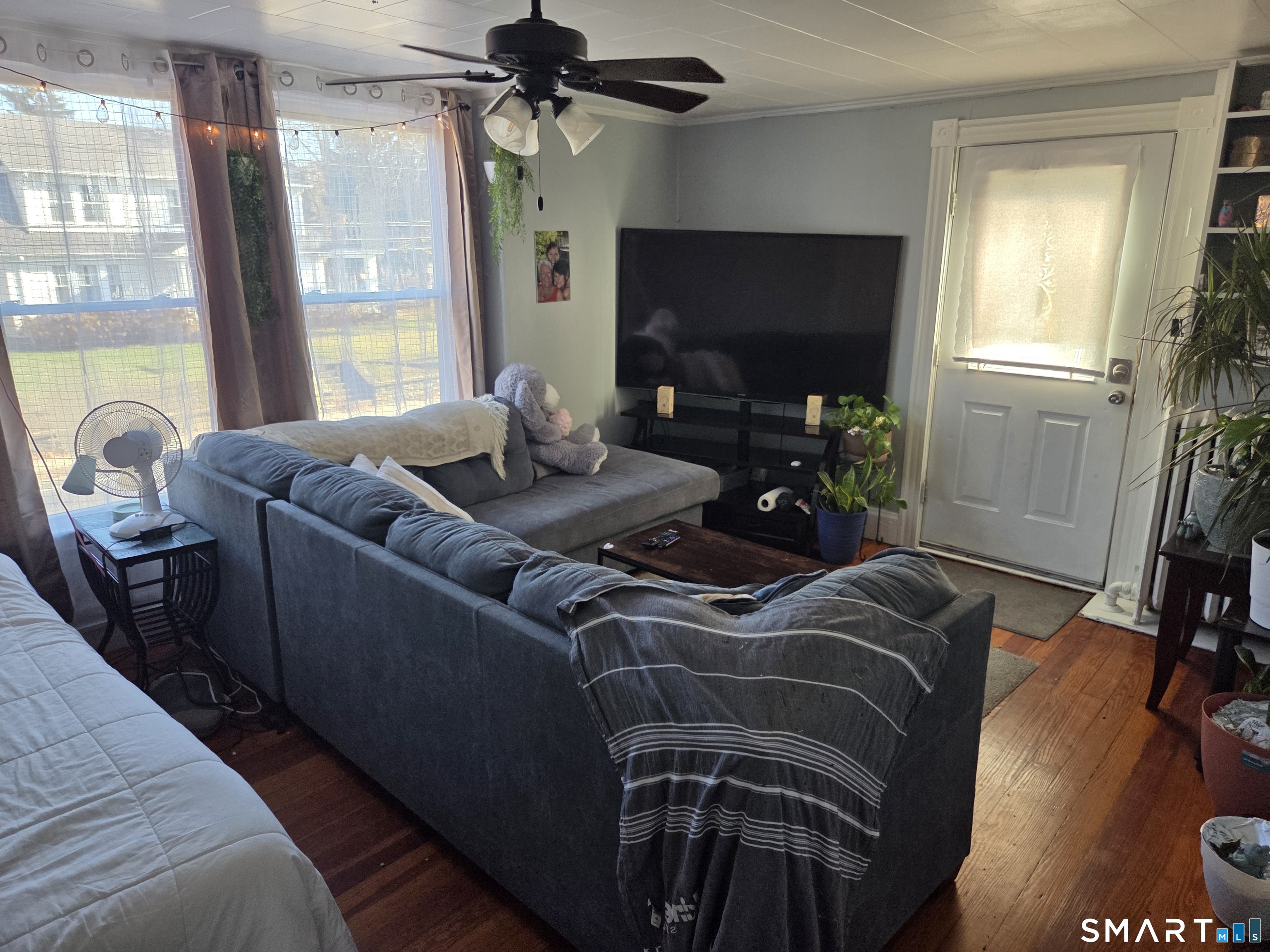 133 Maple Street Killingly, CT 06239 - Photo 7 of 12 a living room with furniture a flat screen tv and a floor to ceiling window