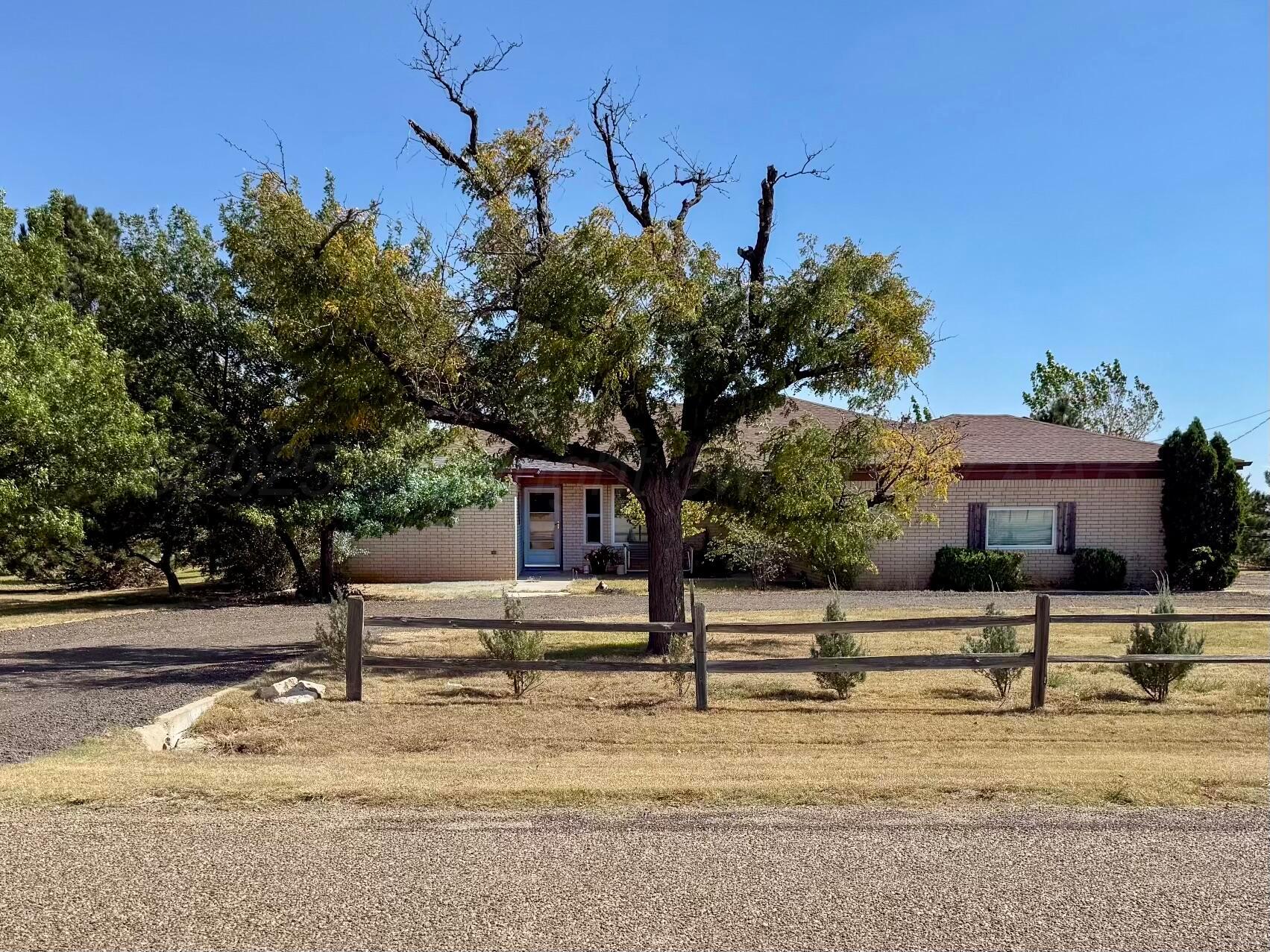 a view of a house with street that has a tree