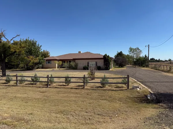 a view of a house with a yard and potted plants