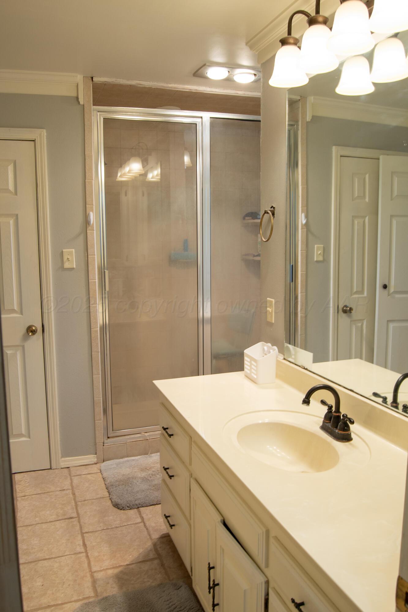 14653 Halsey Trail Amarillo, TX 79118 - Photo 45 of 66 a bathroom with a sink and mirror with shower