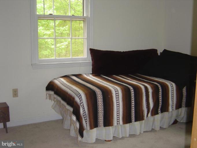 138 Windy Pines Road Front Royal, VA 22630 - Photo 5 of 17 a bed sitting in a bedroom next to a window