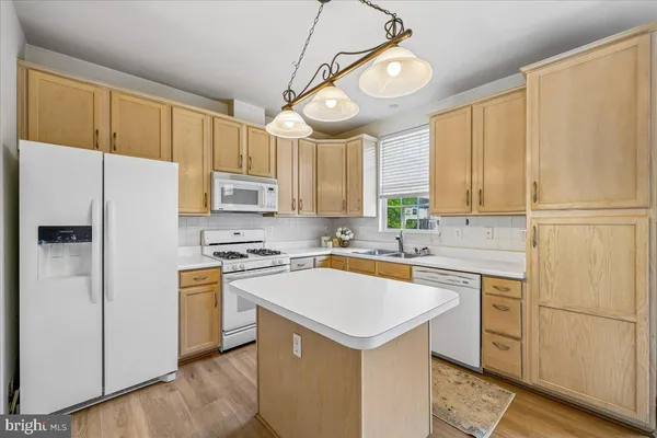a kitchen with cabinets and wooden floor