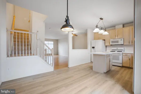 an empty room with wooden floor mirror and windows