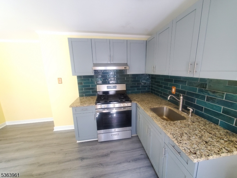 935 East Front Street Plainfield, NJ 07062 - Photo 14 of 25 a kitchen with stainless steel appliances granite countertop a sink stove and refrigerator