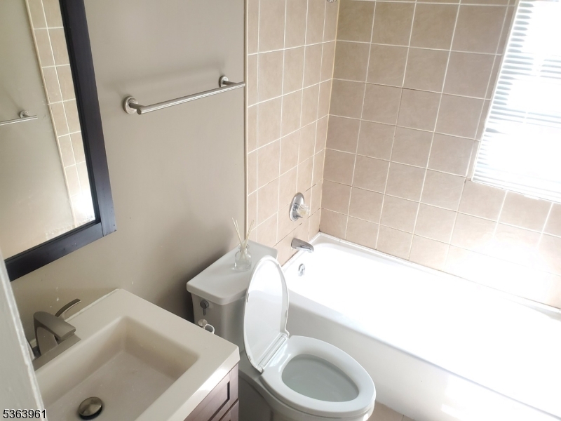 935 East Front Street Plainfield, NJ 07062 - Photo 19 of 25 a bathroom with a sink a toilet and shower