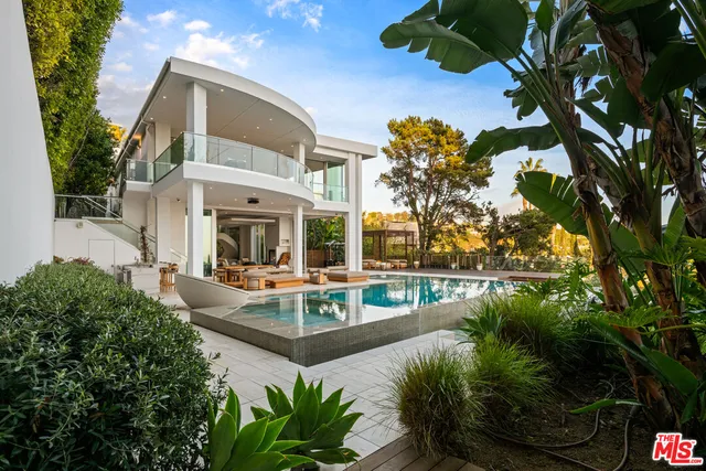 a view of a house with pool lawn chairs and couches with wooden floor