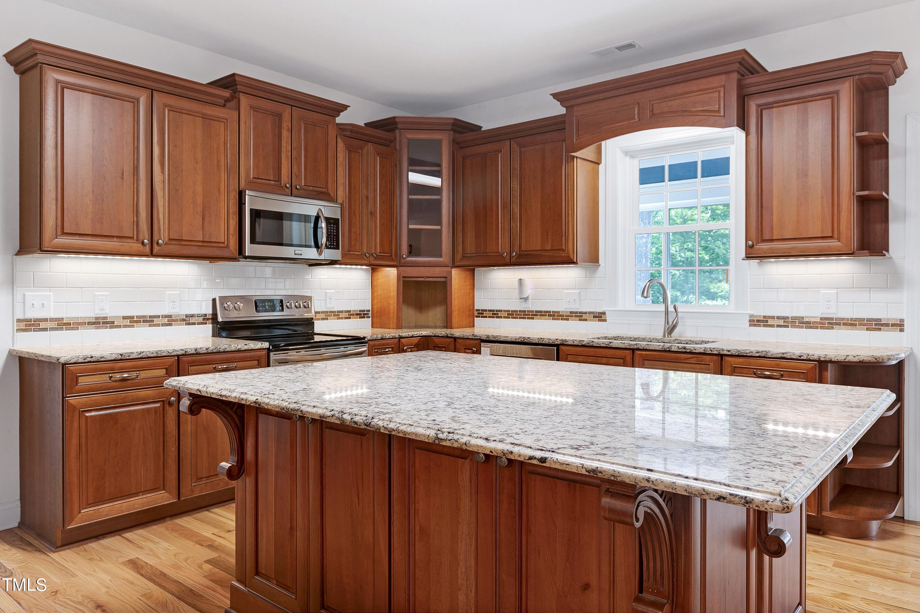 644 Uwharrie Ridge Road Chapel Hill, NC 27516 - Photo 20 of 43 a kitchen with granite countertop a sink a stove and cabinets