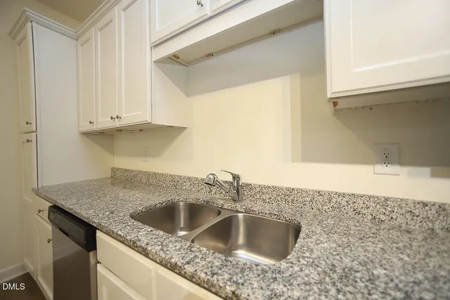 a kitchen with granite countertop a sink and a stove