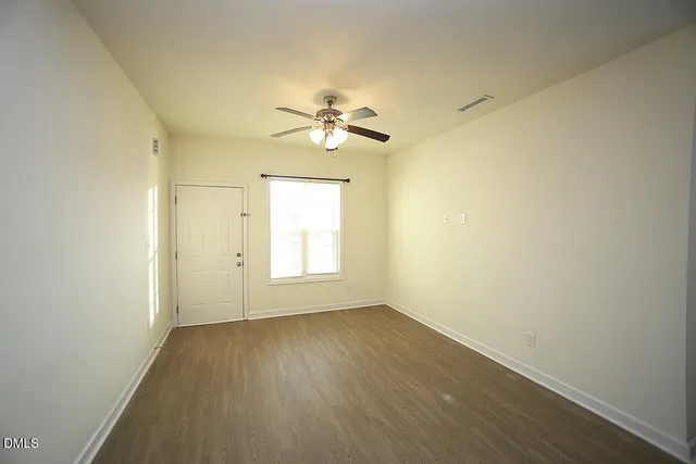 an empty room with a window and a ceiling fan