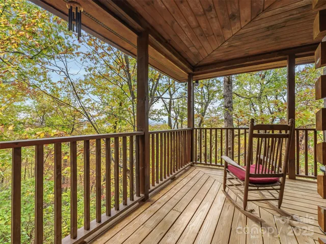 a balcony with chairs and wooden fence