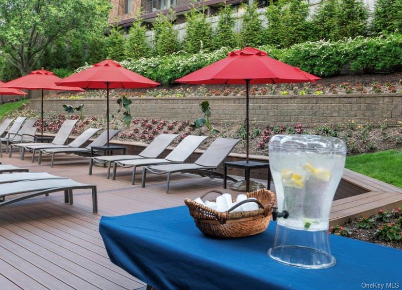 1 Bay Club Drive, Unit 6V Queens, NY 11360 - Photo 19 of 21 a table and chairs with the umbrella in the background