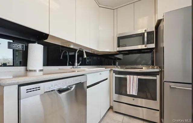 a kitchen with stainless steel appliances granite countertop a stove and a microwave