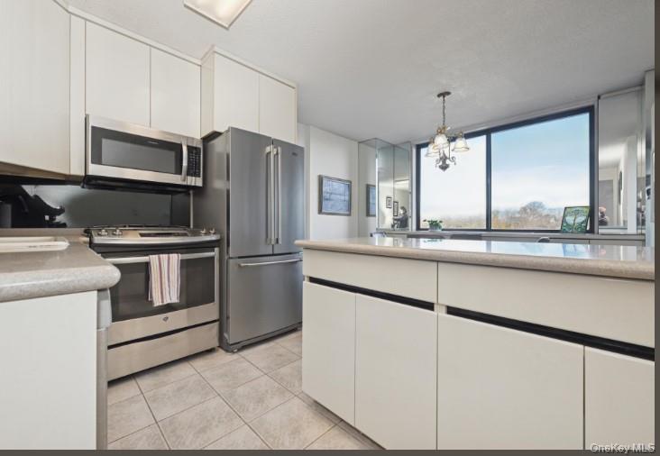 1 Bay Club Drive, Unit 6V Queens, NY 11360 - Photo 10 of 21 a kitchen with kitchen island granite countertop a sink and stainless steel appliances