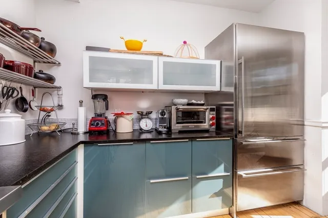 a kitchen with stainless steel appliances granite countertop a sink and a refrigerator