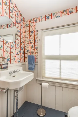 a bathroom with a sink and a white bath tub sitting next to a window