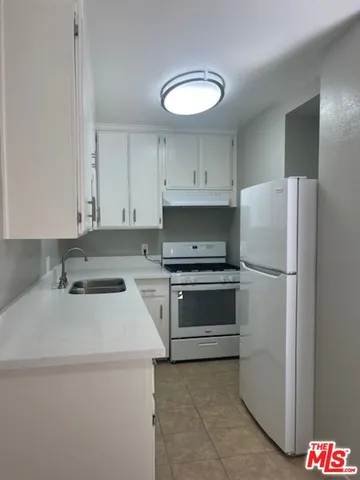 a kitchen with a white stove and white cabinets