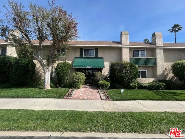 a front view of a house with a yard and trees