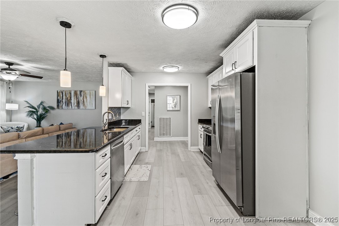 780 Wayside Road Raeford, NC 28376 - Photo 11 of 37 a kitchen with a sink refrigerator and cabinets