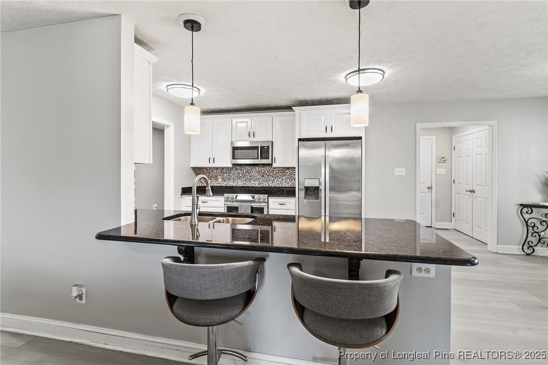 780 Wayside Road Raeford, NC 28376 - Photo 12 of 37 a kitchen with stainless steel appliances granite countertop a sink a refrigerator and a stove