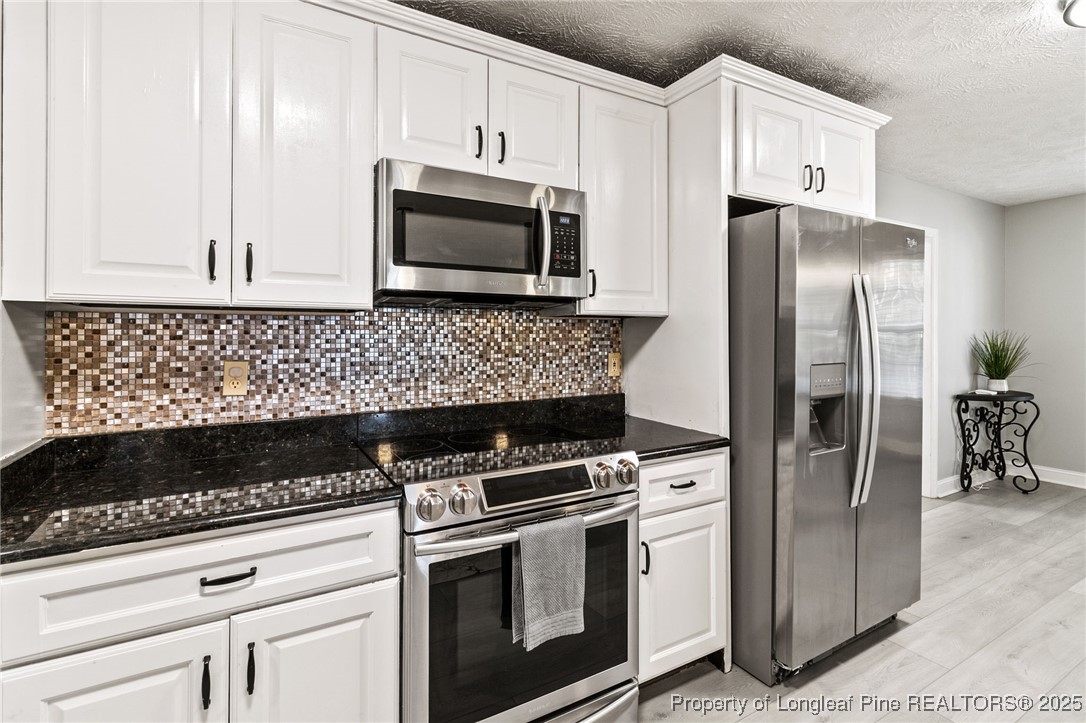 780 Wayside Road Raeford, NC 28376 - Photo 14 of 37 a kitchen with granite countertop white cabinets stainless steel appliances and a counter space