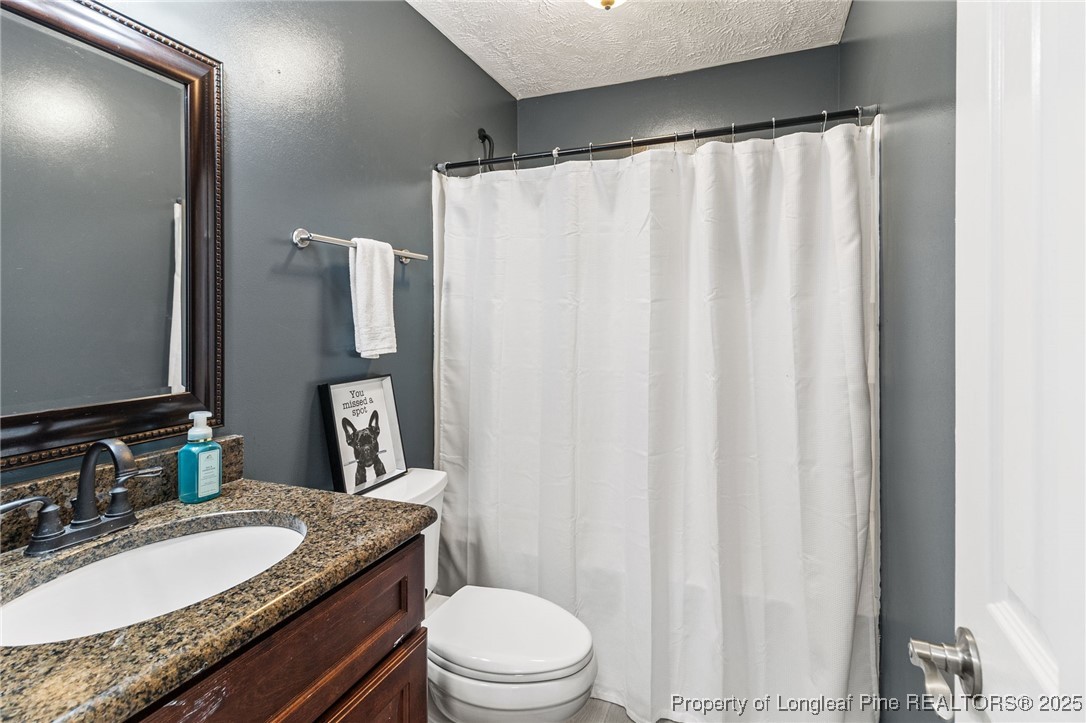 780 Wayside Road Raeford, NC 28376 - Photo 25 of 37 a bathroom with a granite countertop sink and a mirror