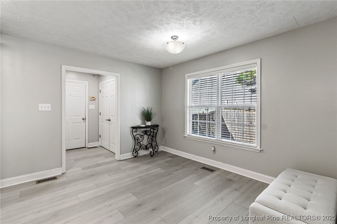 780 Wayside Road Raeford, NC 28376 - Photo 9 of 37 a view of an empty room with a window and wooden floor