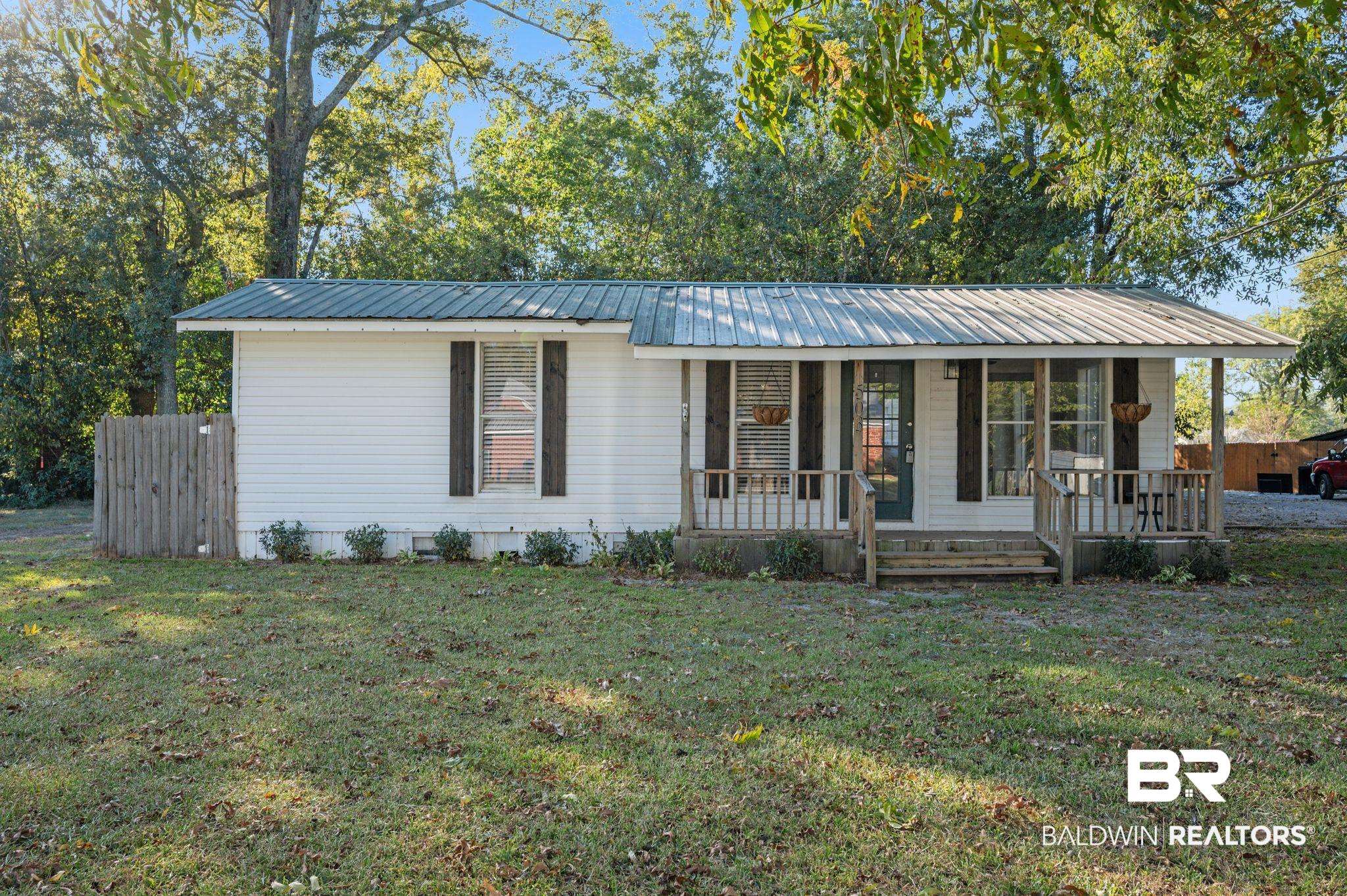 503 North Holly Street Foley, AL 36535 - Photo 1 of 23 Ranch-style home featuring a porch and a front yard