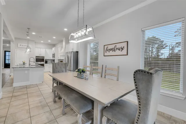 a view of a dining room and livingroom view with furniture wooden floor and a chandelier