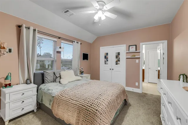 a spacious bedroom with a large bed and a chandelier