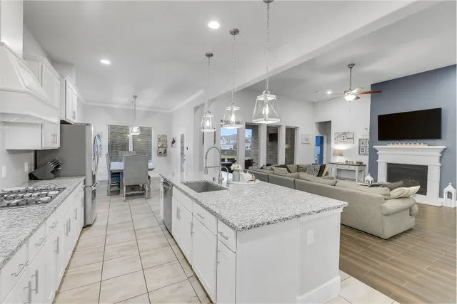a large white kitchen with a stove and a large window