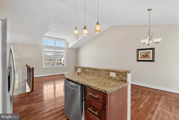 a kitchen with a sink a chandelier and wooden floor