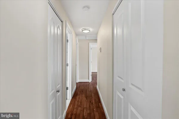 a view of a hallway with wooden floor and a glass door