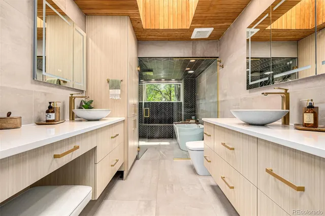a spacious bathroom with a double vanity sink a mirror and a shower
