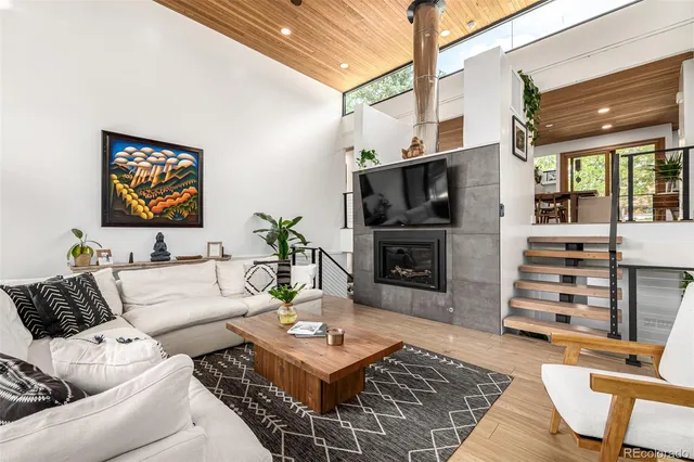 a living room with furniture a flat screen tv and a fireplace