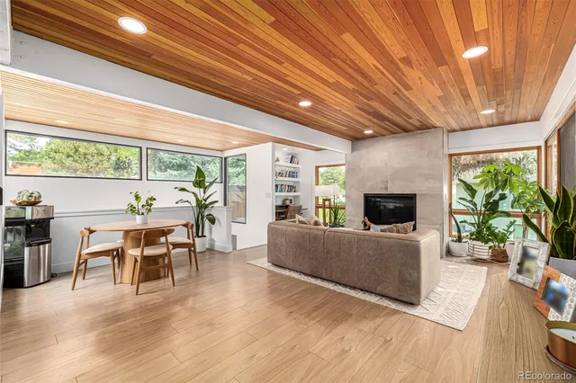 a living room with furniture a fireplace and a wooden floor