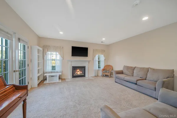 a kitchen with stainless steel appliances granite countertop a refrigerator a sink dishwasher a stove and white cabinets with wooden floor