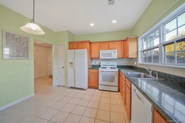 a kitchen with granite countertop cabinets stainless steel appliances a sink and a window