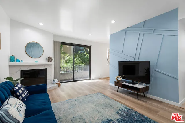 a living room with furniture a fireplace and a flat screen tv