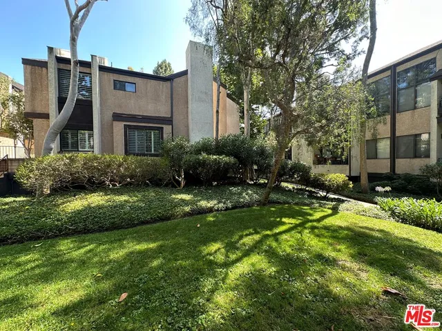 a front view of a house with yard and green space