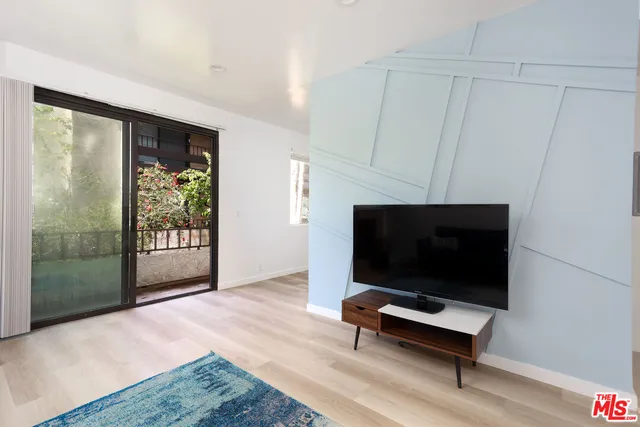 a living room with furniture flat screen tv and a floor to ceiling window