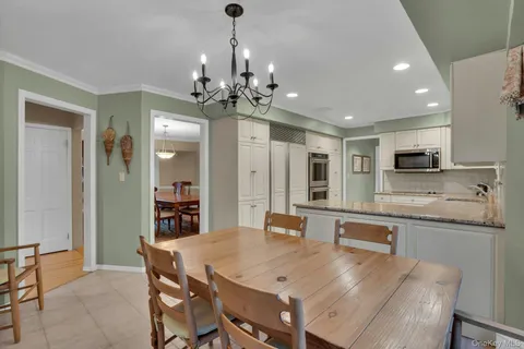 a large kitchen with sink a refrigerator and dining table