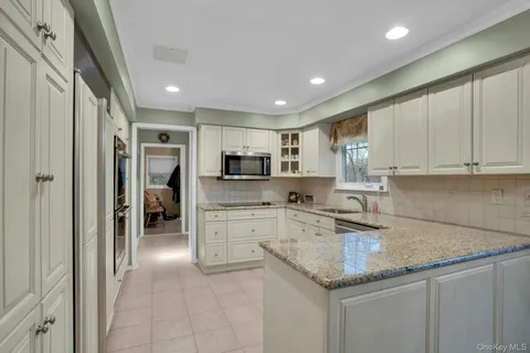 a kitchen with granite countertop cabinets stainless steel appliances a sink and a counter top space