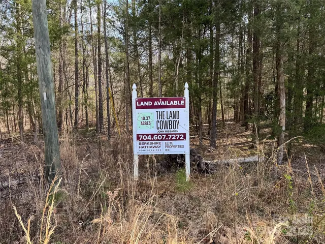 a sign board with tall trees