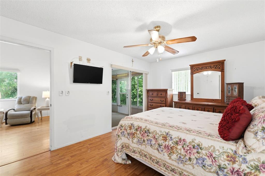4544 Slippery Rock Road New Port Richey, FL 34653 - Photo 17 of 32 a bedroom with a bed a couch and a flat tv screen on dresser