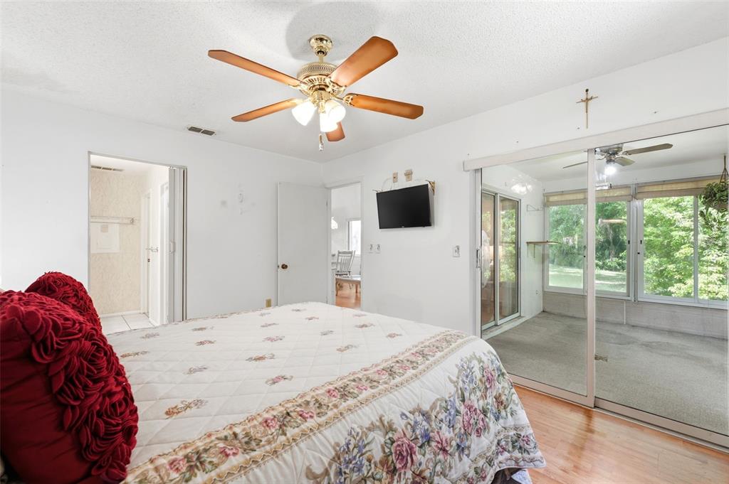 4544 Slippery Rock Road New Port Richey, FL 34653 - Photo 18 of 32 a bedroom with a large bed and a flat screen tv