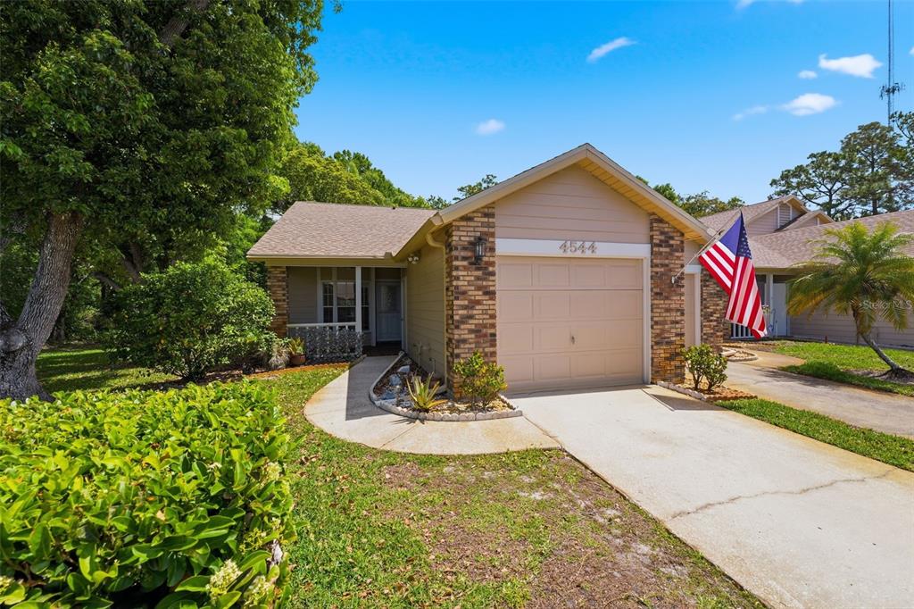 4544 Slippery Rock Road New Port Richey, FL 34653 - Photo 3 of 32 a front view of a house with a yard and garage