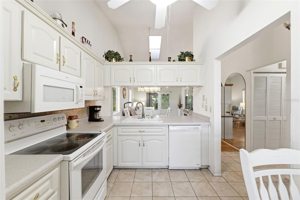 4544 Slippery Rock Road New Port Richey, FL 34653 - Photo 7 of 32 a kitchen with white cabinets a sink and white appliances